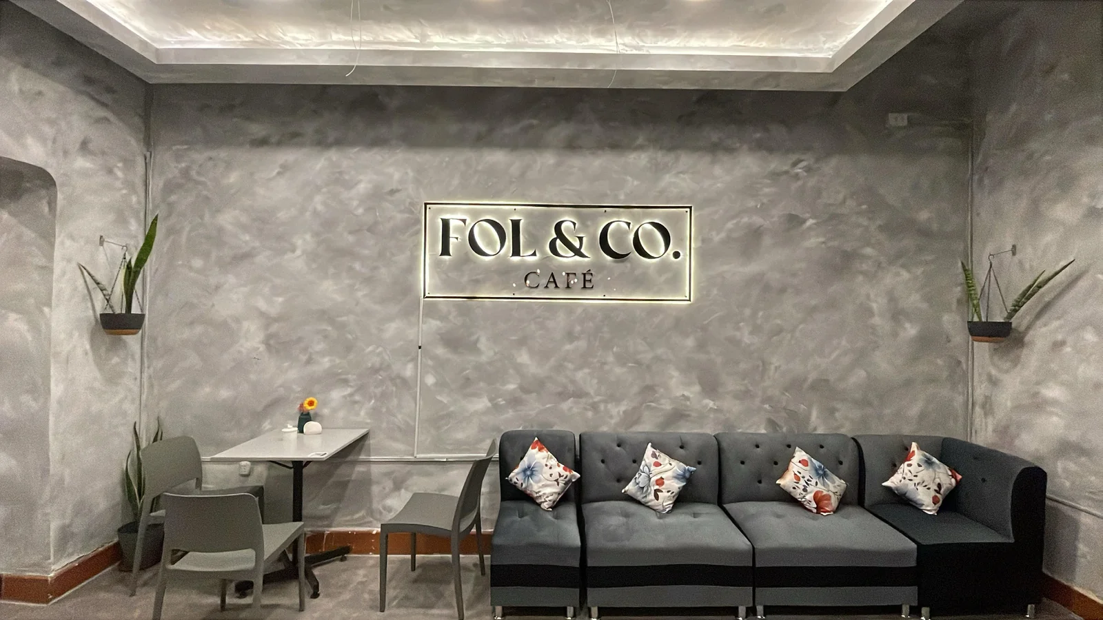 Interior de FOL & CO. Café en Arequipa: microcemento, sofá y luz baja